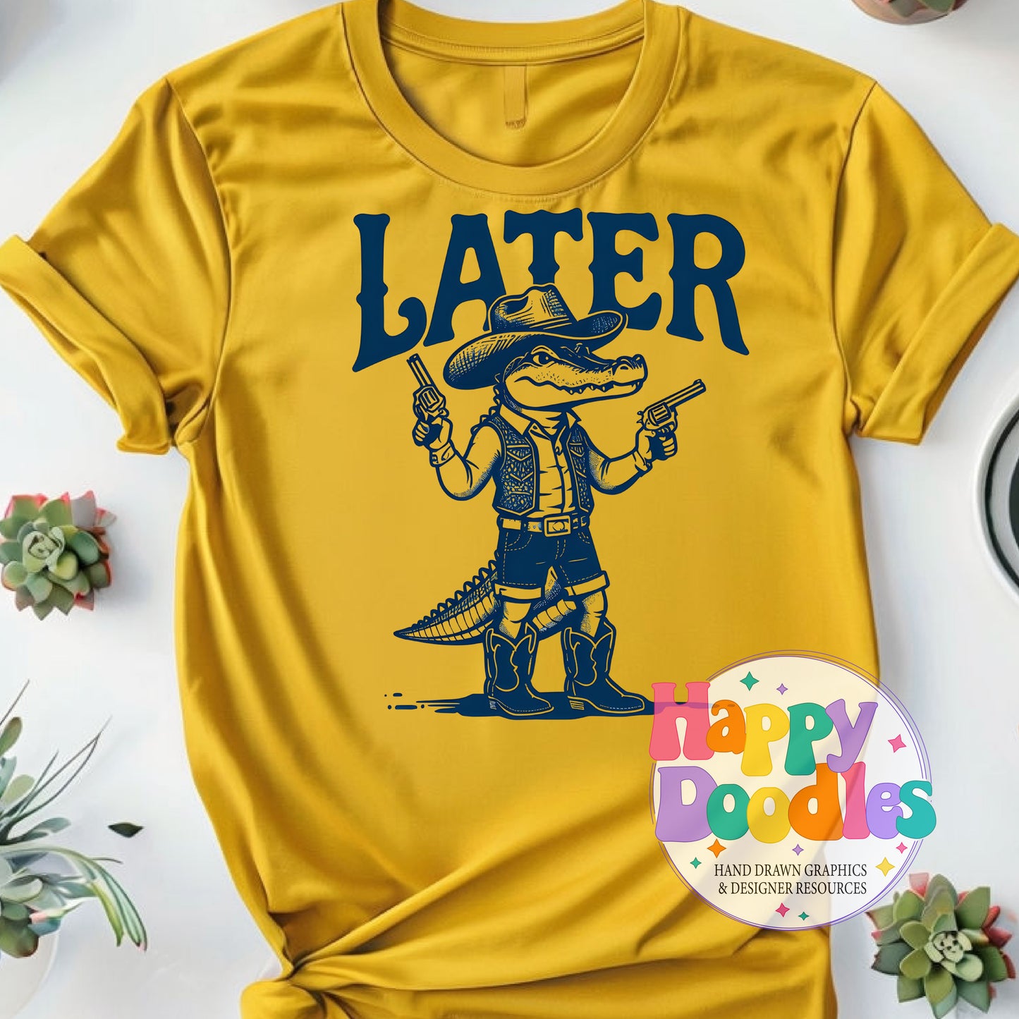 Yellow t-shirt with a graphic of a crocodile in cowboy attire holding guns and the word 'LATER' on a white background.